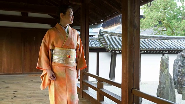 穿着和服的高级妇女在寺庙里散步视频素材