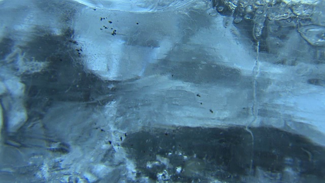 一系列极端的特写镜头，通过透明的冰岛海岸线上的冰形成的水流的退潮。视频下载