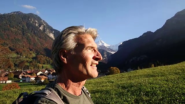 日出时分，一名男性徒步旅行者穿过山地草地视频下载