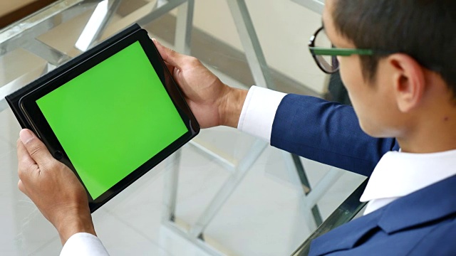 过肩拍摄使用数码平板电脑，绿色屏幕视频素材