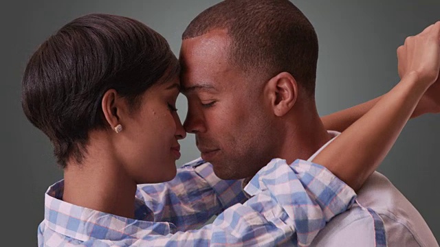 非裔美国男人和女人拥抱在灰色梯度的背景视频素材