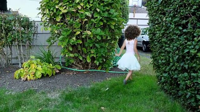 夏天的晚上，年轻的女孩穿着短裙在院子里玩耍视频下载