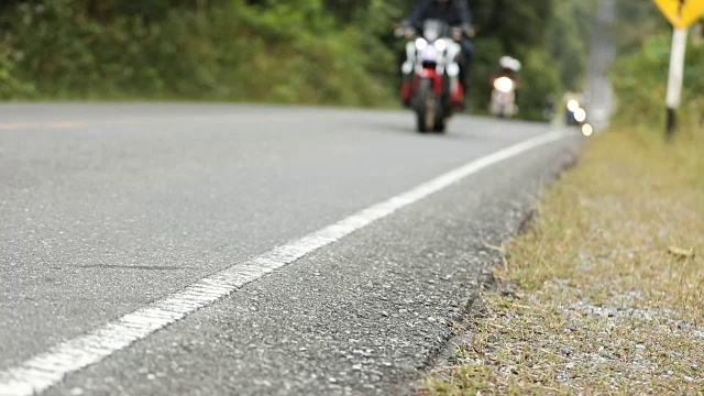 一个模糊的男人骑着摩托车在山路上视频下载
