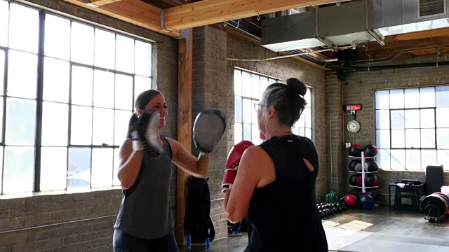 MS微笑教练与成熟的女性客户拳击在健身房工作视频下载
