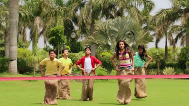 五个十几岁的男孩和女孩在玩套袋比赛，德里，印度视频素材