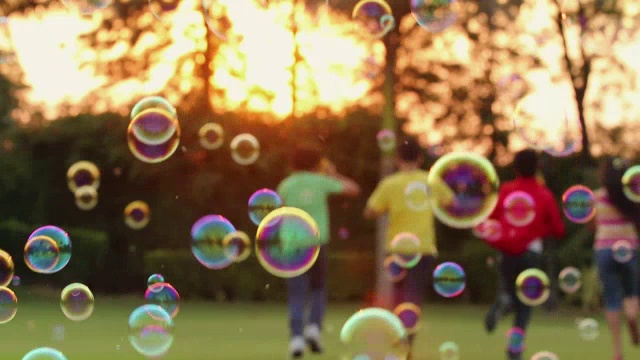 四个十几岁的男孩和女孩享受泡泡棒在公园，德里，印度视频素材