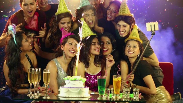 一群年轻人在生日聚会上用手机自拍视频下载