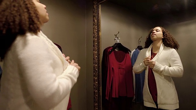 一个女人试穿一件羊毛衫的中镜头视频下载