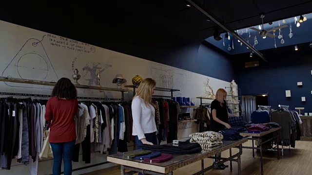 跟踪拍摄到两个女人进入一家服装店视频下载