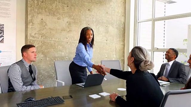 MS TS成熟的女商人在办公室的会议室里与一群商务人士握手视频下载