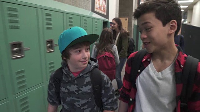 两个朋友在学校走廊上聊天的中间镜头视频素材