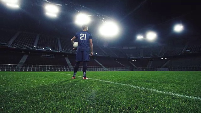 一个足球运动员在一个空的体育场晚上的肖像视频素材