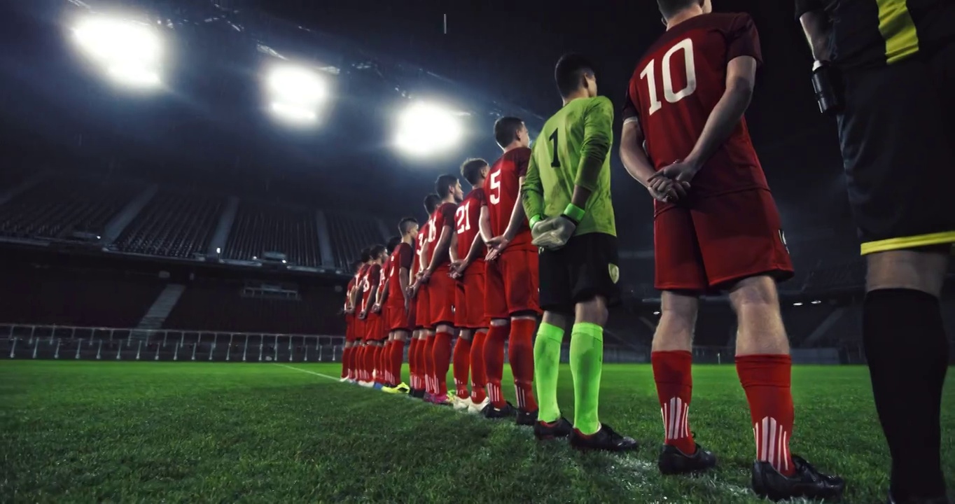 在一个下雨的体育场，穿着红色制服的足球运动员的肖像视频素材