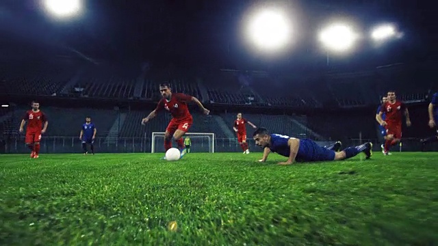 足球运动员在一场晚间比赛中运球视频素材