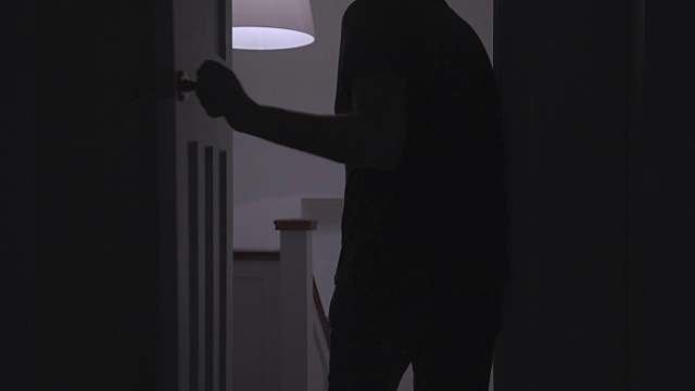 一个男人离开黑暗房间的剪影。视频素材