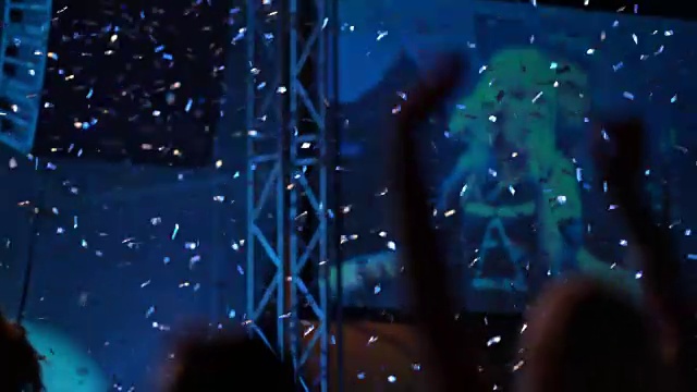 SLO MO女人在音乐会上在五彩纸屑雨中跳舞视频素材