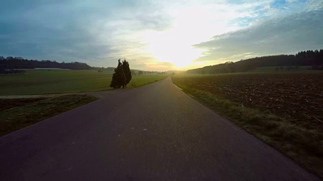 汽车在日落时分行驶在乡间的道路上视频素材