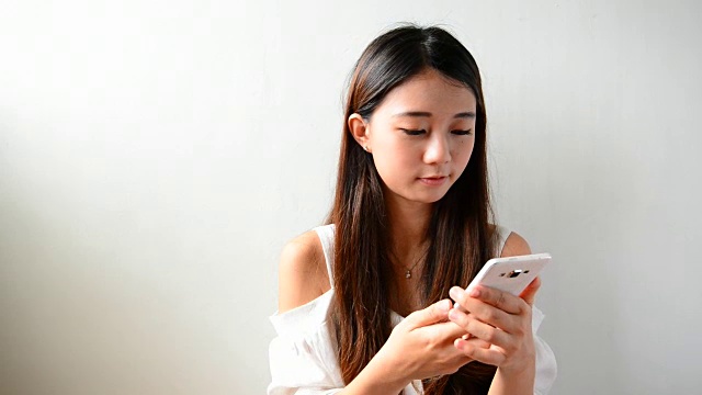 年轻的亚洲女性使用智能手机视频素材