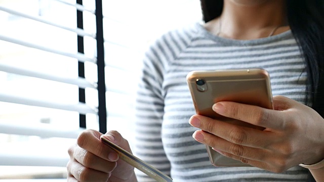 年轻女子用智能手机在网上购物视频下载