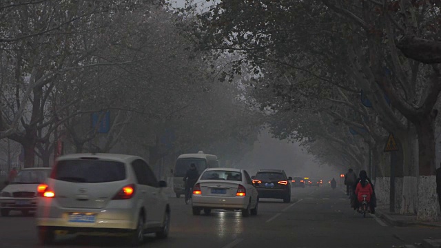 清晨的街道上，行人和车辆被雾霾笼罩视频下载
