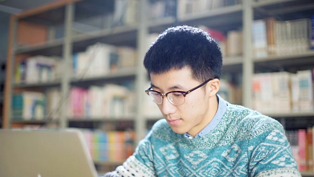 一名学生使用笔记本电脑学习视频下载