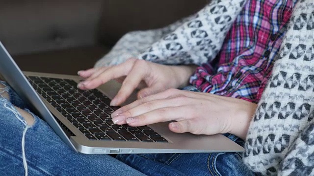 一个年轻女孩的手在笔记本电脑上打字视频素材
