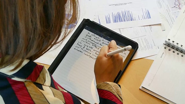 4K:肩膀上的女人用手写笔在平板电脑上写字视频下载