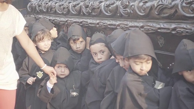 身穿黑色服装的孩子们抱着的天主教雕像。危地马拉安提瓜岛的大斋节/复活节庆典。视频下载