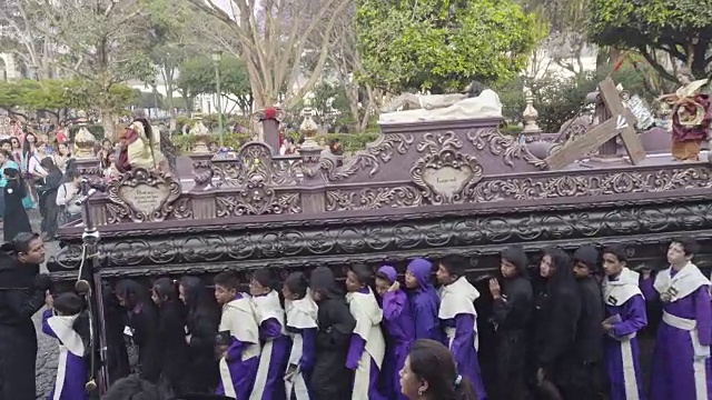 身穿黑色服装的孩子们抱着的天主教雕像。危地马拉安提瓜岛的大斋节/复活节庆典。视频下载