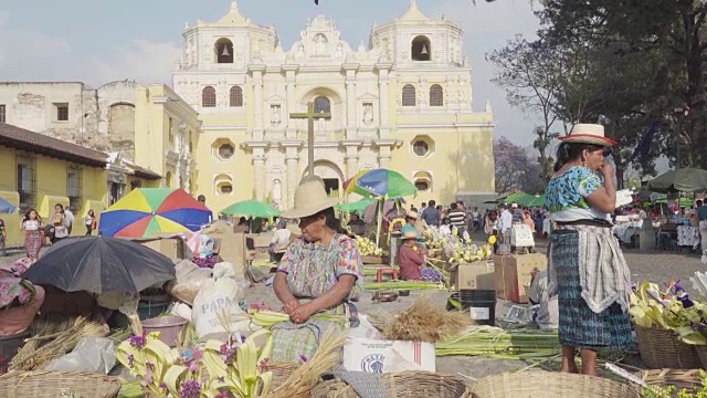 身着玛雅传统服装的妇女在教堂前为棕枝主日制作棕榈。安提瓜危地马拉。视频下载
