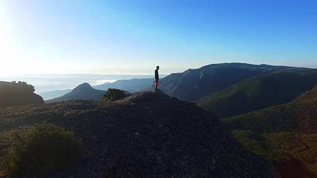 在一次周末旅行中，一名男子在山顶用无人机拍摄了一段航拍镜头，他一边欣赏风景，一边在加泰罗尼亚比利牛斯山脉拍摄照片。视频素材