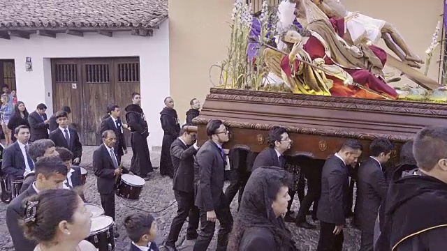 耶稣基督的雕像由穿着黑色服装的人抬着。大斋节复活节庆典期间，危地马拉安提瓜的天主教游行。视频下载
