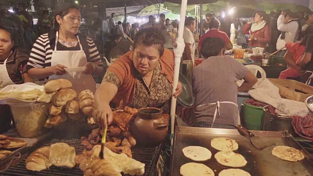 危地马拉安提瓜的街头食品市场。西班牙妇女烹饪烤肉和玉米饼卷视频下载