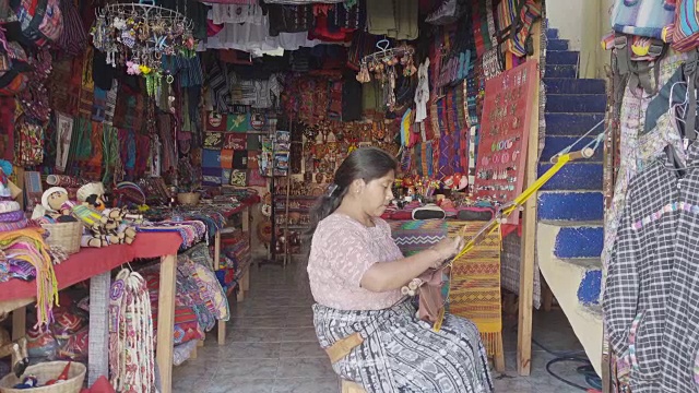 一名妇女在纪念品商店编织玛雅传统服装视频下载