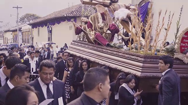 大斋节复活节庆典期间，危地马拉安提瓜的天主教游行。身穿黑色服装的妇女抱着基督雕像。视频下载