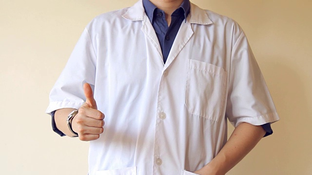 身份不明的男医生在白人背景下竖起大拇指视频下载