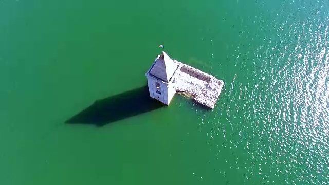 无人机拍摄的航拍画面显示，这座紧急教堂淹没在加泰罗尼亚地区Sau水库的水中。4 k UHD。视频素材