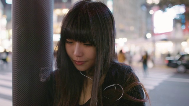CU日本东京，一名年轻的日本女子查看手机，看着相机视频素材