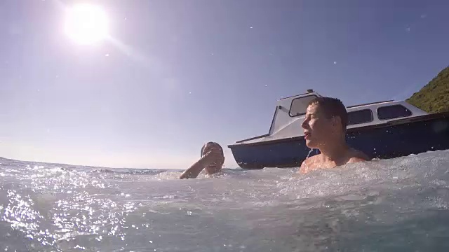 一对从船上跳进海里的夫妇视频素材