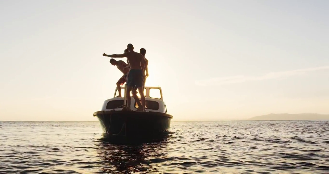 SLO MO夫妇和他们的朋友在日落时跳船视频素材