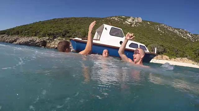POV三个朋友从船上跳进海里视频素材