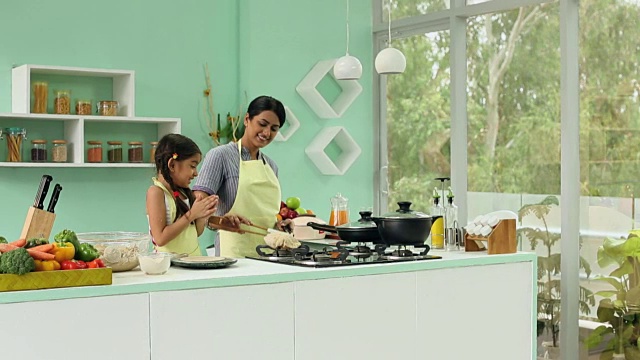 母亲和她的女儿在家庭厨房做饭，德里，印度视频素材
