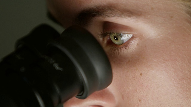 一个女人在实验室里看显微镜视频下载