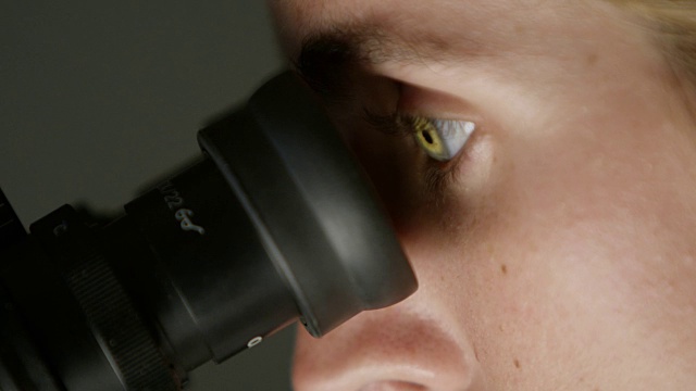 一个女人在实验室里看显微镜视频素材