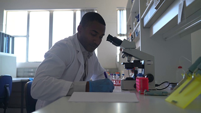 在实验室里使用显微镜的男性科学家视频下载