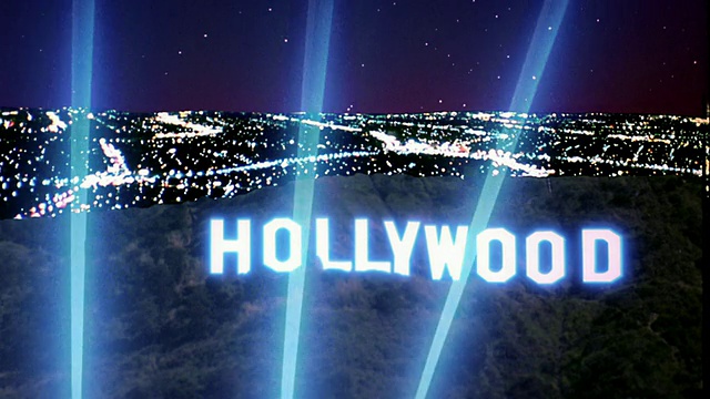大镜头好莱坞标志与聚光灯和灯光的圣费尔南多谷在夜间/加利福尼亚的背景视频素材