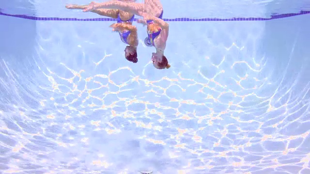 两位女花样游泳运动员在水下进行例行的水下观察视频素材