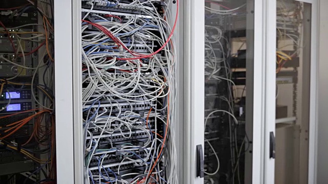 男技术员在服务器室的电缆上施压视频素材