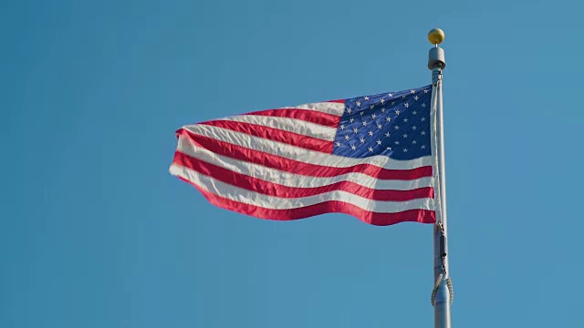 美国国旗在晴朗的蓝天下飘扬视频素材