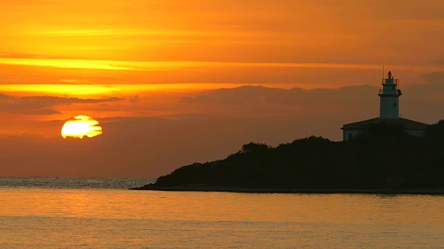 西班牙巴利阿里群岛，马略卡岛，阿尔库迪亚港附近的Alcanada灯塔的日出视频素材